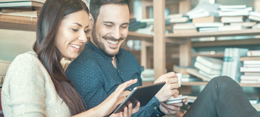pareja sonriente mirando una tablet