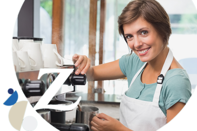 trabajadora de una cafetería calentando leche en la cafetera