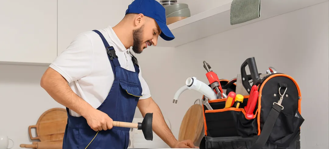 Fontanero arreglando el desagüe de la cocina