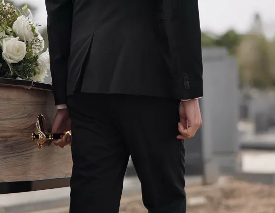 Hombre llevando el ataúd en un cementerio