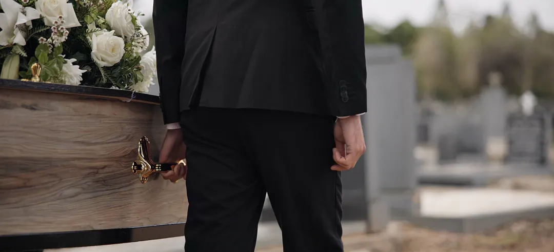 Hombre llevando el ataúd en un cementerio