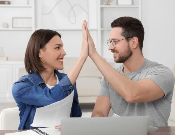 Pareja chocando las manos revisando papeles