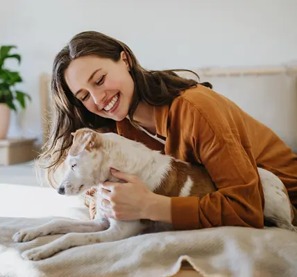 chica sonriente acariciando su perro