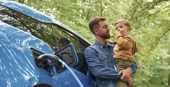 padre e hijo recargando un coche eléctrico
