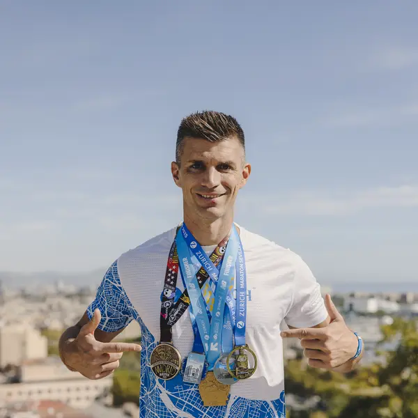 corredor mostrando las medallas de 5 maratones