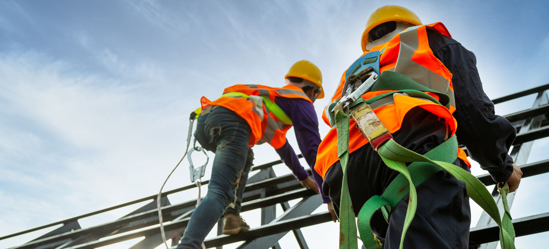 Trabajadores subiendo por un andamio con el equipo de seguridad