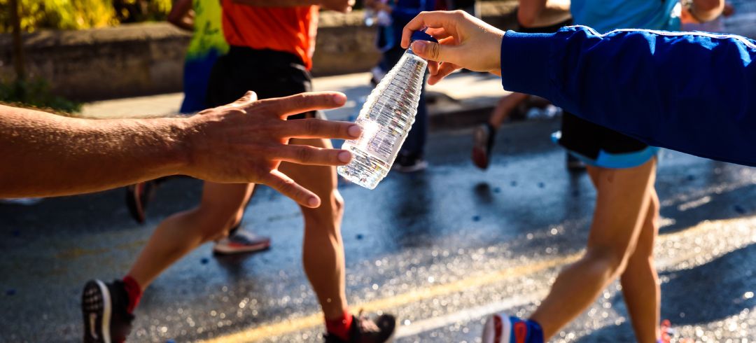corredores recibiendo una botella de agua